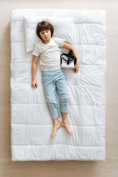 Charming boy tired after using gadget - 写真・画像