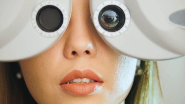 Clínica oftalmológica - mulher verifica visão por equipamento moderno - olho esquerdo
 - Foto, Imagem