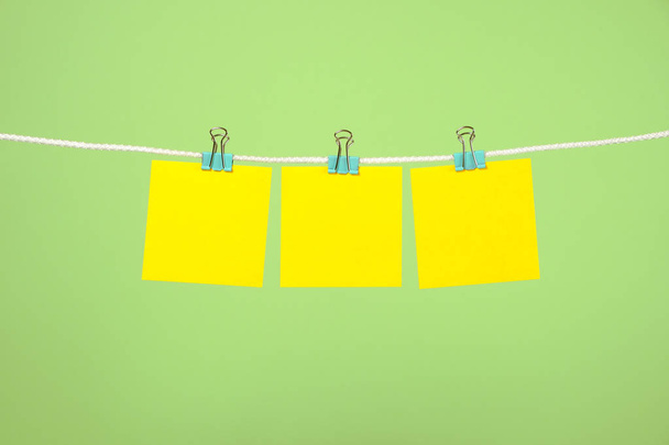 Blank yellow paper notes on clothesline - 写真・画像