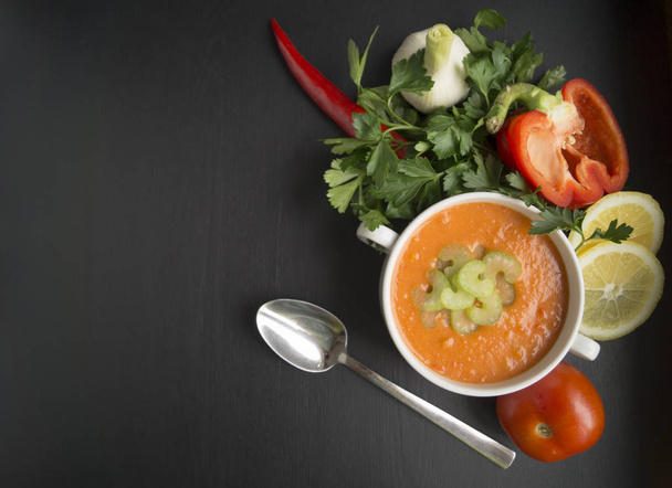 томатный суп с овощами и зеленью на черном фоне
 - Фото, изображение