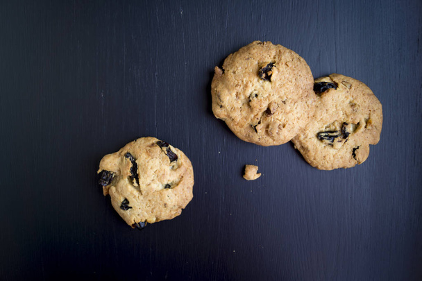 σπιτικά μπισκότα με σταφίδες σε μαύρο φόντο - Φωτογραφία, εικόνα