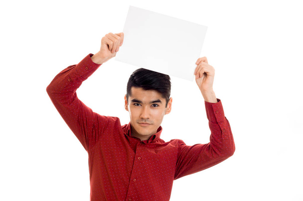 young cute male model in red shirt with empty placard in hands isolated on white background - Фото, изображение
