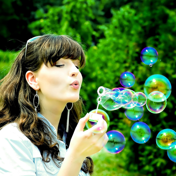 Young girl blowing soap bubbles - Fotografie, Obrázek