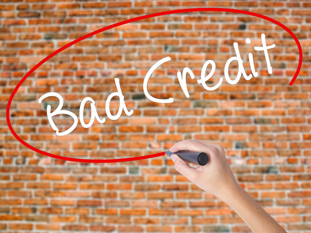 Frau schreibt schlechte Kreditwürdigkeit mit schwarzem Filzstift auf Bildschirm - Foto, Bild