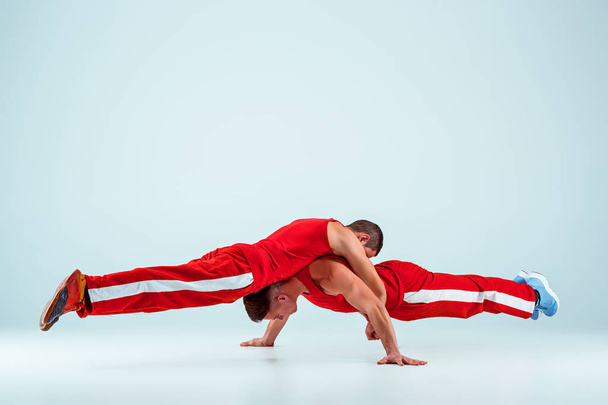 The two gymnastic acrobatic caucasian men on balance pose - Zdjęcie, obraz