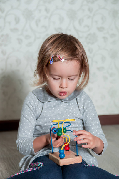 Dítě hrající s bludiště. Malá holčička řešit hádanky. Vzdělávací hračka.  - Fotografie, Obrázek