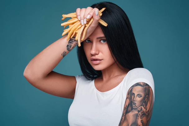 Mooie charmante tattoo girl met frietjes - Foto, afbeelding