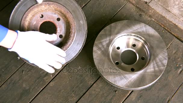 Mechanic with gloves showing worn rusty brake disk. - Footage, Video