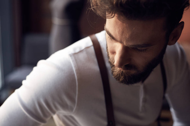 Closeup portrait of handsome bearded man wearing white shirt with brown leather suspenders - Foto, immagini