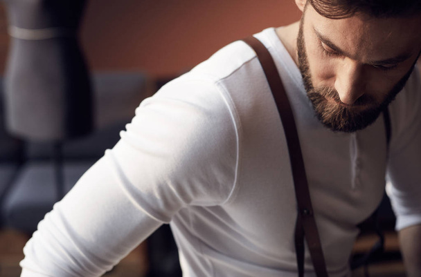 Closeup portrait of handsome bearded man wearing white shirt with brown leather suspenders - Фото, изображение
