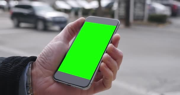 Ο άνθρωπος κατέχει πράσινη οθόνη Smartphone σε μια πόλη - Πλάνα, βίντεο