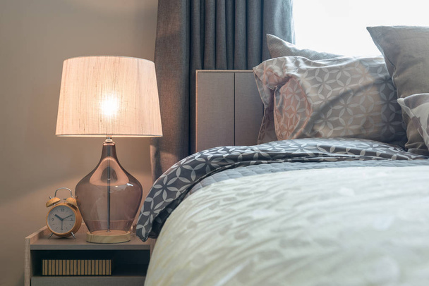 style lampe classique avec réveil sur le côté de la table dans une chambre confortable
 - Photo, image