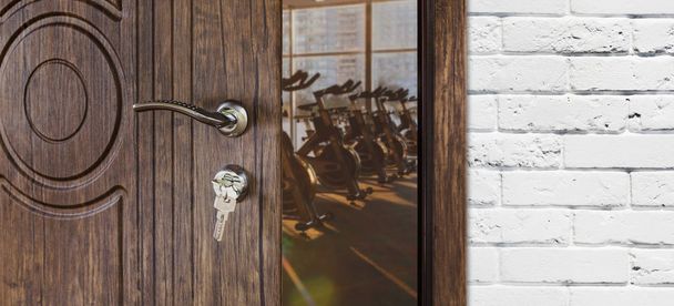 Entrance to gym in fitness club, opened door with exercise bikes - Photo, Image