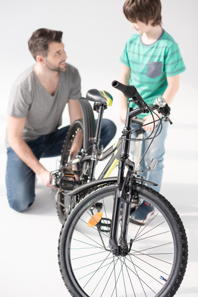 Father and son inflating bicycle tire - Φωτογραφία, εικόνα