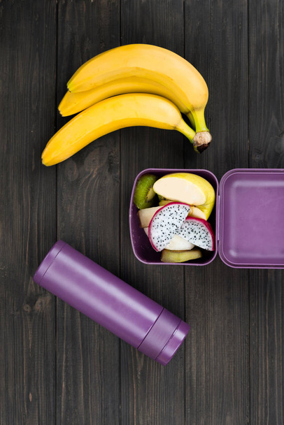 Sweet fruits lying in violet lunch box - Фото, зображення