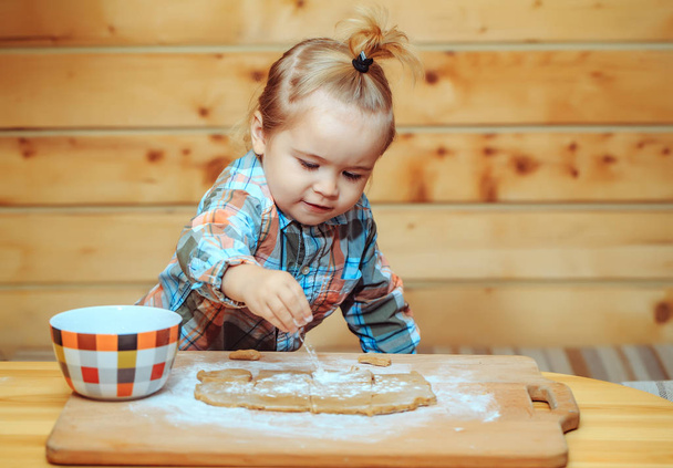 cute child cooking with dough, flour and bowl on wood - Фото, зображення