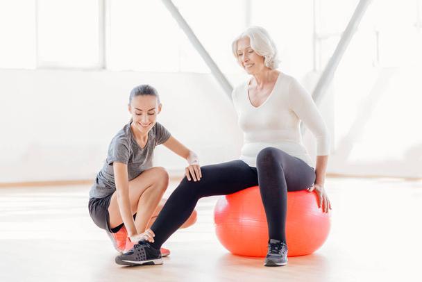 Joyful elderly woman sitting on the fitness ball - Foto, afbeelding