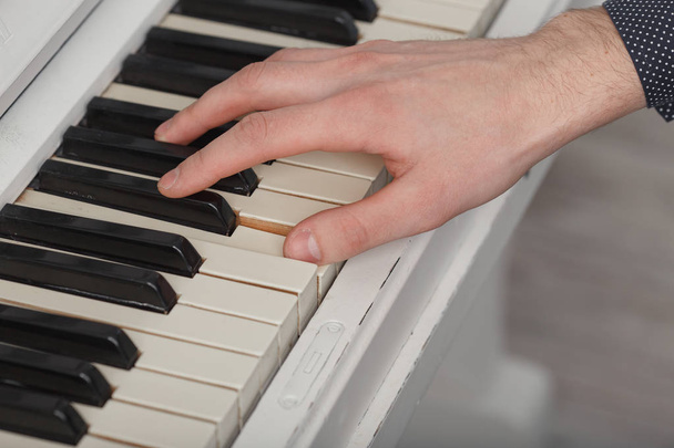 A young man playing piano closeup. - Photo, image