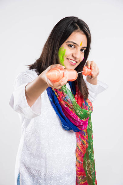 индийская красивая молодая женщина с пичкари, готовая распылять цвета на фестивале Холи, изолированная на белом фоне с копировальным пространством - Фото, изображение