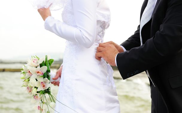 las manos que aprietan el corsé a la novia
 - Foto, Imagen