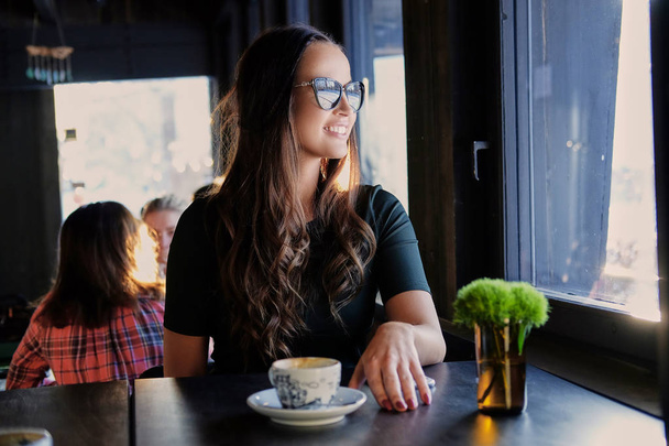 Femme brune souriante dans un café
 - Photo, image