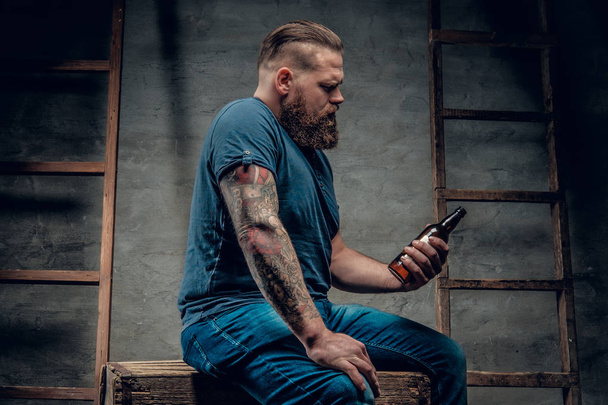 Homem barbudo segurando garrafa de cerveja
 - Foto, Imagem