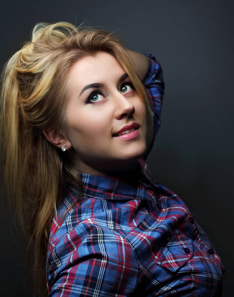 Blonde girl in a checkered shirt .Red and blue lights.Portrait. - Foto, Imagen