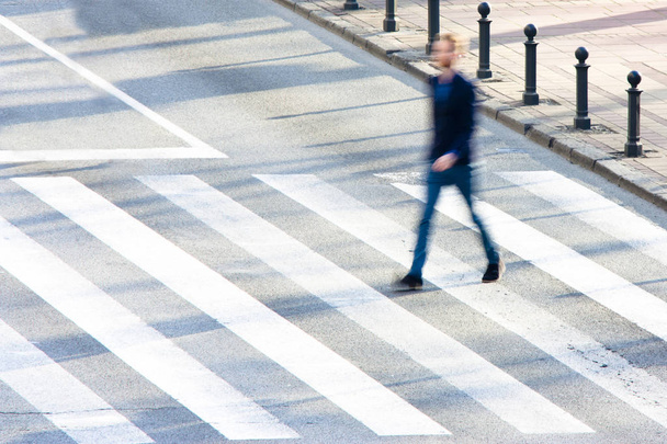 Defocused zebra crossing with a young man in motion - Fotografie, Obrázek