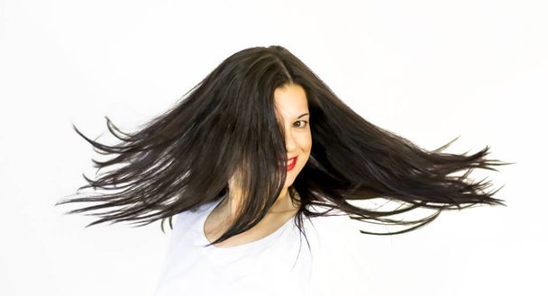 Портрет красивой молодой женщины, трясущей волосами
  - Фото, изображение