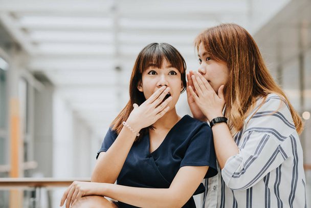 Young Asian girl whispering gossip with surprise face - Foto, Bild