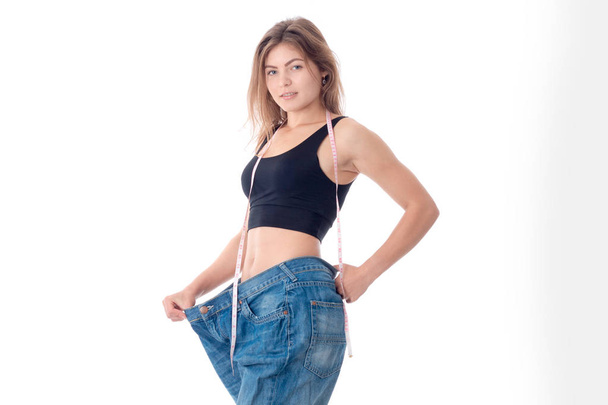 Slim ragazza atletica si estende mano grandi pantaloni larghi isolati su sfondo bianco
 - Foto, immagini