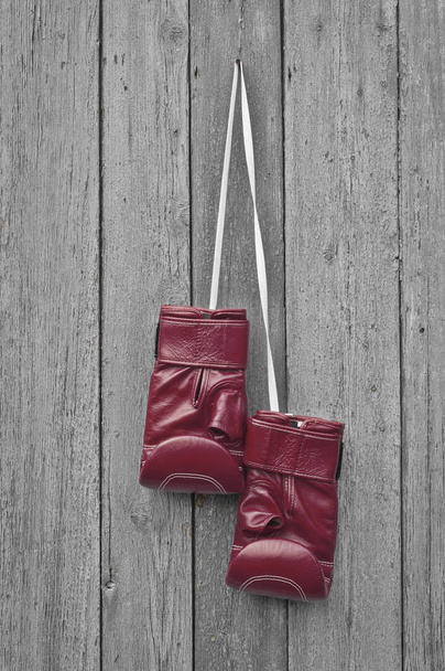 Rode bokshandschoenen leer hangt aan een spijker - Foto, afbeelding