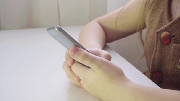   petite European girl enjoys a smartphone. Close-up of the phone in children's hands - Footage, Video