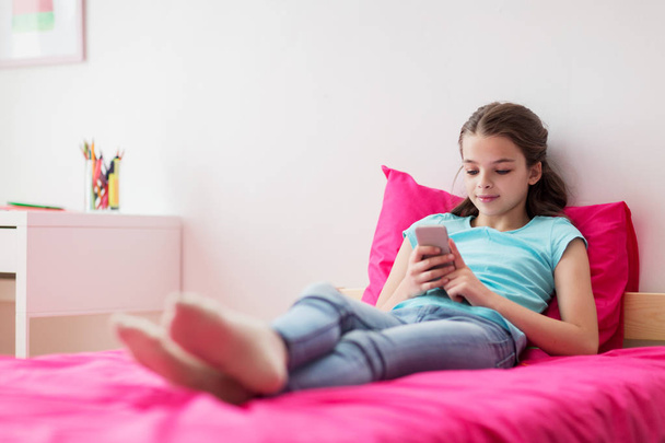 smiling girl texting on smartphone at home - Foto, Bild