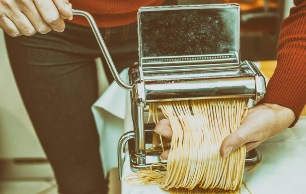 Mujer Chef haciendo fideos caseros simples con máquina de pasta
. - Foto, imagen