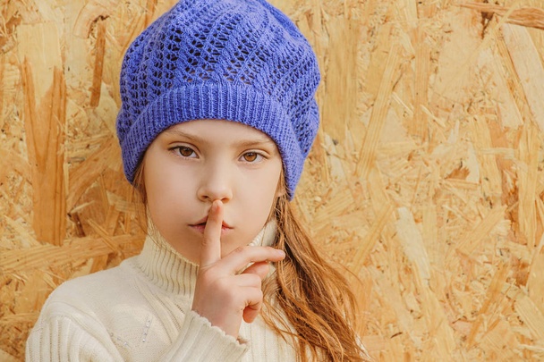 Όμορφο κοριτσάκι στο καπάκι ζητεί τη σιωπή - Φωτογραφία, εικόνα