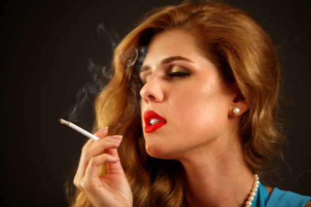 Woman smokes marijuana. Girl who smokes cigarette. - Фото, изображение