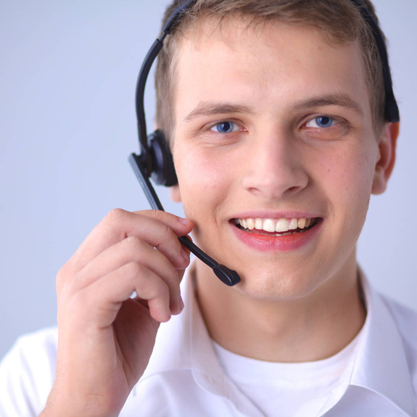 Υποστήριξης πελατών χειριστή με ένα ακουστικό σε άσπρο φόντο - Φωτογραφία, εικόνα