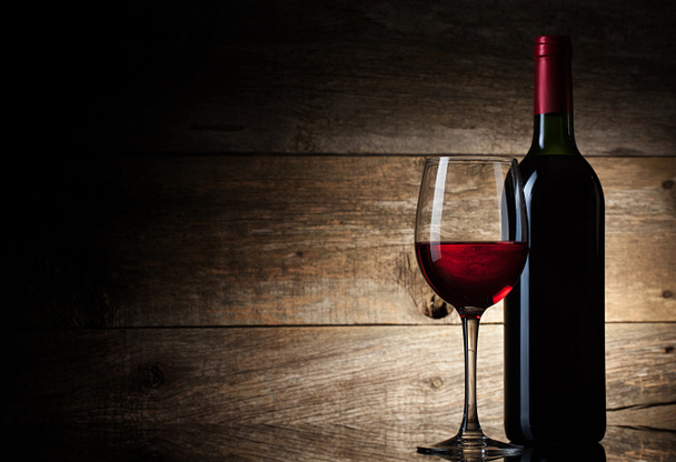 Sklenice na víno a láhev na dřevěném pozadí - Fotografie, Obrázek