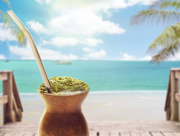 Chimarrao, traditional mate hot tea. Drink of South of the Brazil. Also knowed like mate. On sunny tropical beach landscape background - Photo, Image