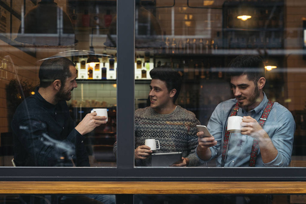 Friends drinking coffee and chatting. - Foto, Bild