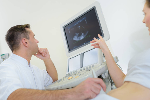 pregnant woman getting ultrasound from doctor in clinic - Fotoğraf, Görsel