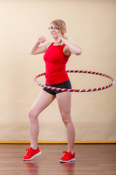 Fit woman with hula hoop doing exercise - Foto, afbeelding