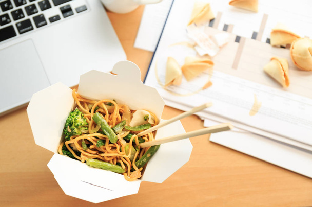 Китайская коробка с едой на столе. Поесть в офисе. Оверт
 - Фото, изображение