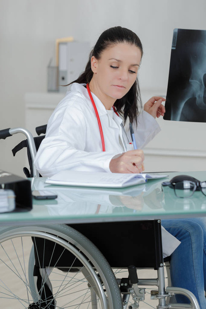 brave disabled female doctor examining x ray - Photo, Image