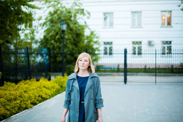 outdoor portrait of young blonde woman, wearing a cloak - Valokuva, kuva