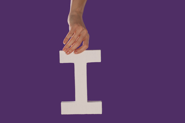 Mão feminina segurando a letra I de cima
 - Foto, Imagem
