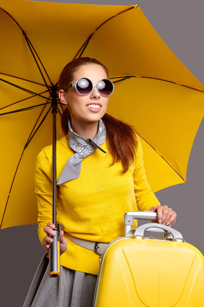 Beautiful girl with a yellow suitcase  - Фото, зображення