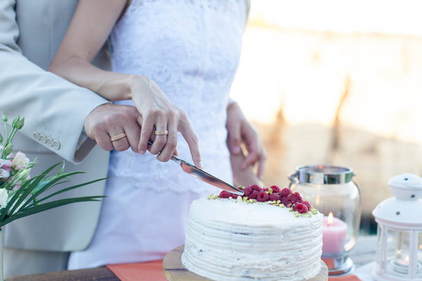 os recém-casados cortaram um belo bolo de casamento branco
 - Foto, Imagem