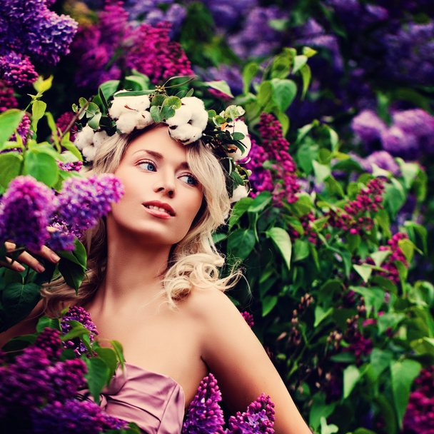 Młoda Blondynka z kwiatami w ogrodzie wiosna - Zdjęcie, obraz